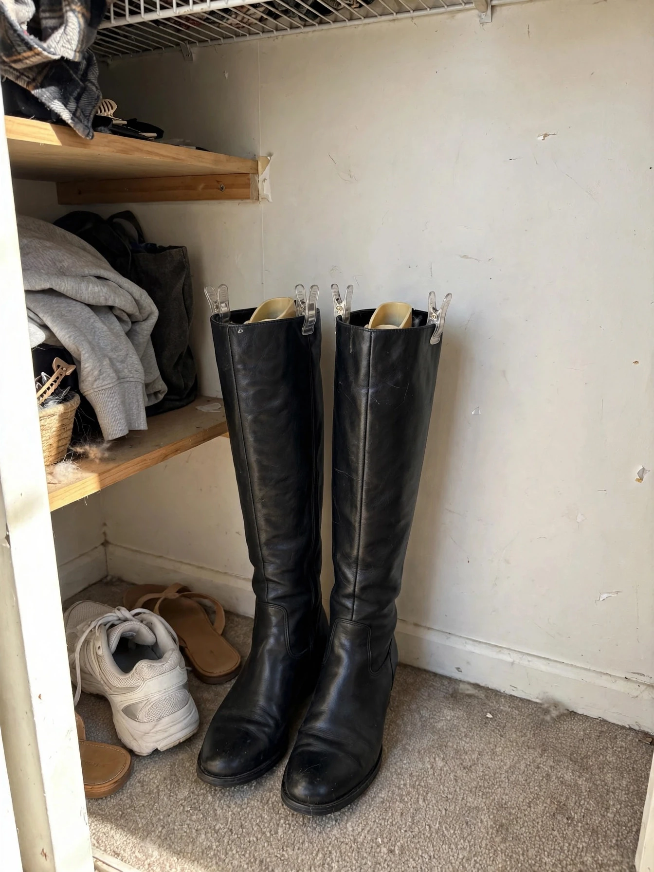 Compact shoe storage in a small closet with pairs arranged in stackable boxes and a low rack