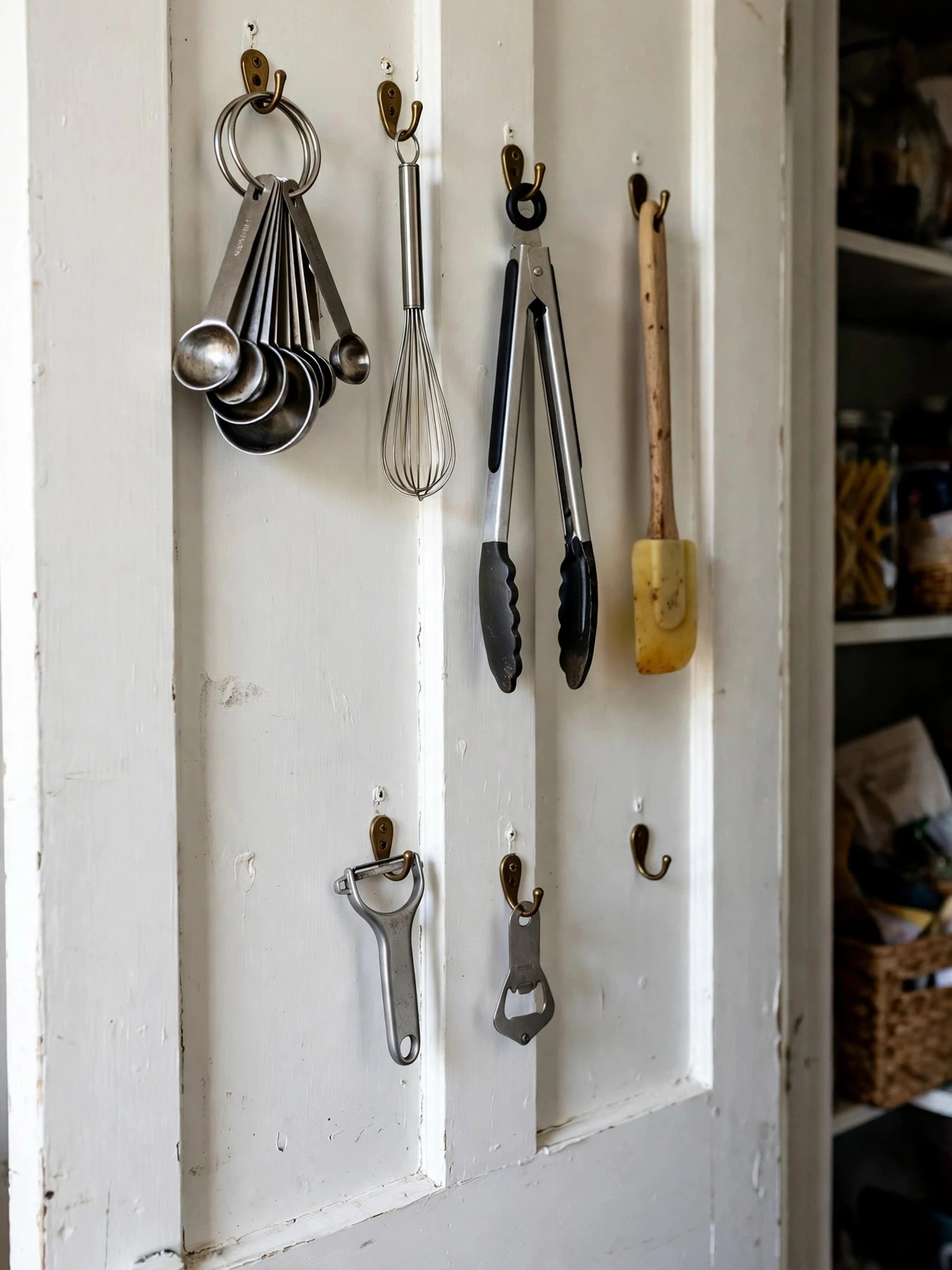 Over-door pantry rack holding spices, jars and packets on the back of a pantry door
